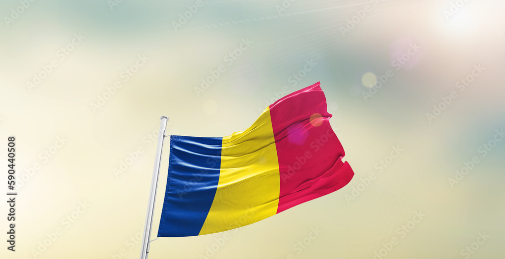 Waving Flag of Chad on blur sky. The symbol of the state on wavy cotton fabric.