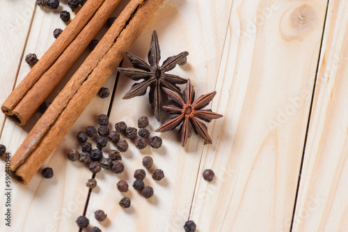 Spices and herbs. Food and cuisine ingredients. Cinnamon sticks, anise stars and black peppercorns on a wooden background.