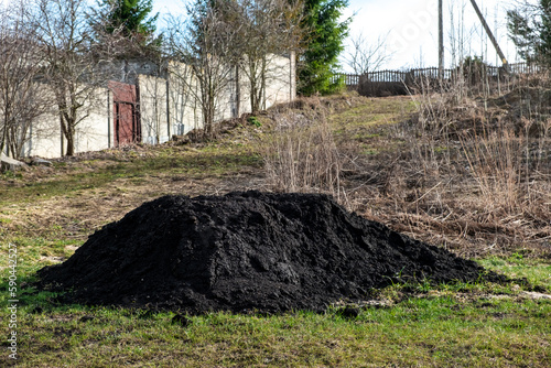 Big pile of black fertile soil. Peat chernozem. Ground for using in the greenhouse og in the garden for planting