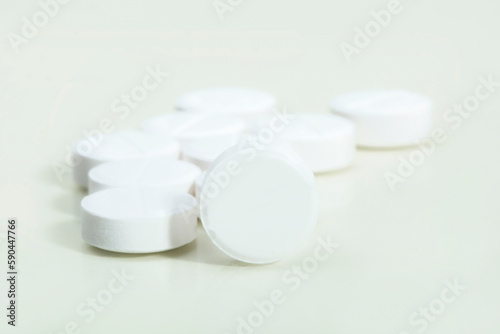 Close up shots of medicine tablets and capsules on white background. White and colored tablets placed in a group.