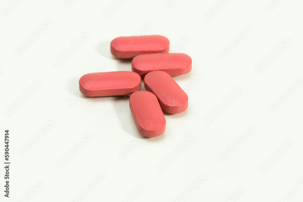 Close up shots of medicine tablets and capsules on white background. White and colored tablets placed in a group. Close up shots of medicine tablets and capsules on white background. White and colored tablets placed in a group.