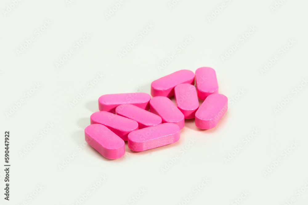 Close up shots of medicine tablets and capsules on white background. White and colored tablets placed in a group. Close up shots of medicine tablets and capsules on white background. White and colored tablets placed in a group.