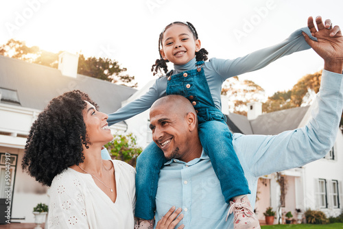 Happy, parents and carrying girl on shoulder relax in garden for bonding, quality time and playing outdoors. Love, family and dad with mom, child and kid smile on summer vacation, weekend and freedom #590447917