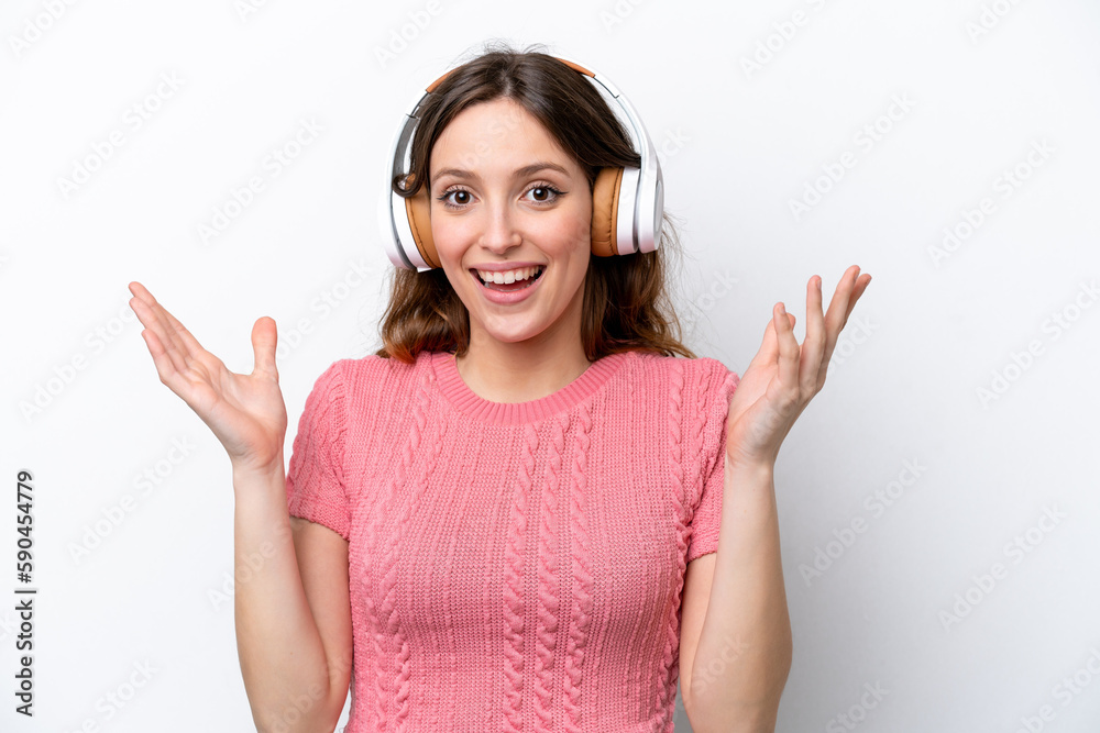 Young caucasian woman isolated on white background surprised and listening music Young caucasian woman isolated on white background surprised and listening music