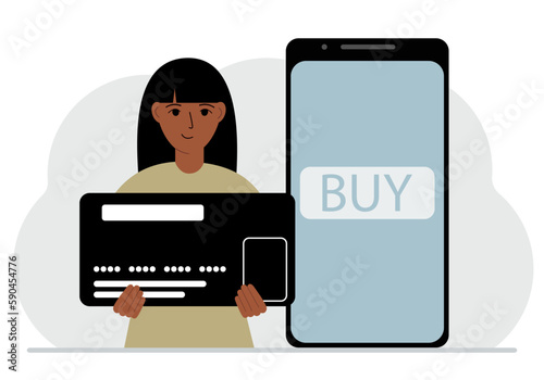 A woman holds a huge credit card next to a smartphone with a Buy button on the screen. The concept of online payments with payment via mobile phone.