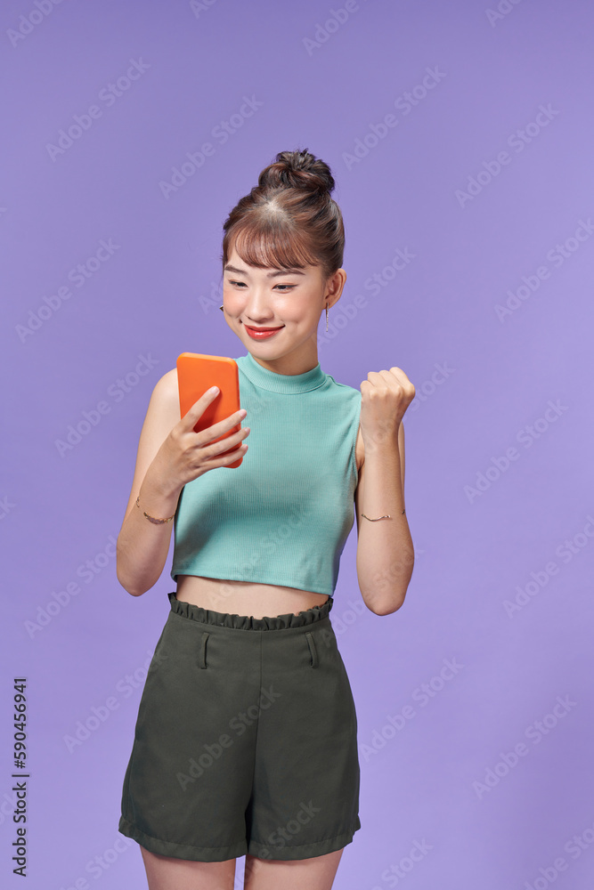 Happy Asian woman holding a smartphone and winning the prize. Happy Asian woman holding a smartphone and winning the prize.