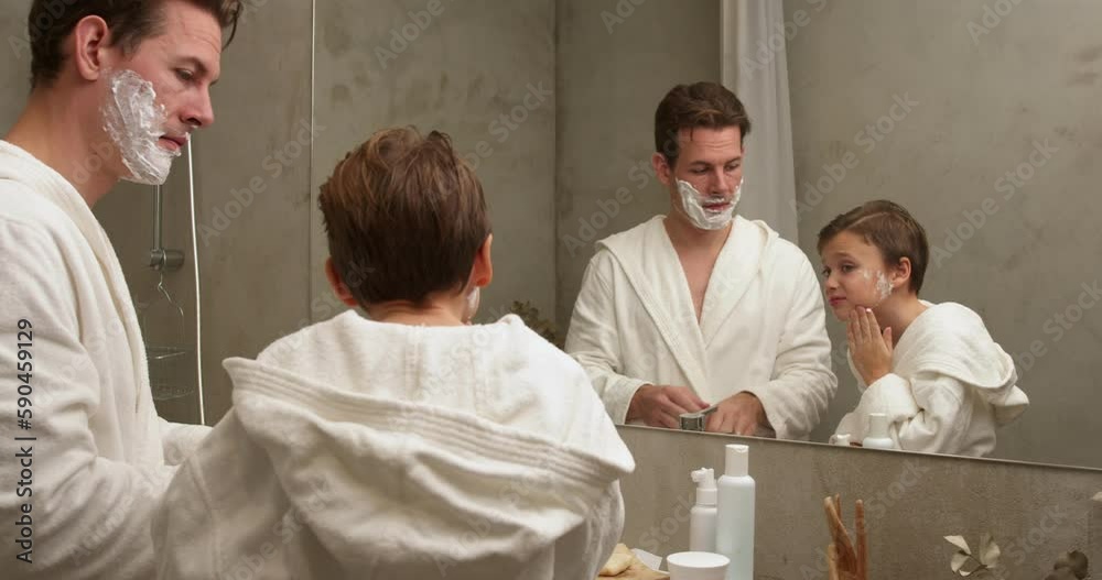 Dad and son washing face after shaving foam on faces in bathroom, spend
