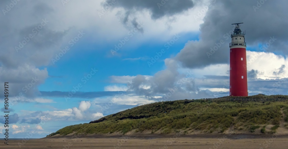 Texel lighthouse on the hill against a cloudy sky