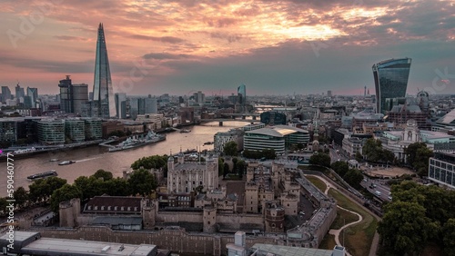 Aerial shot of the tower of London with boats on river Thames at sunset