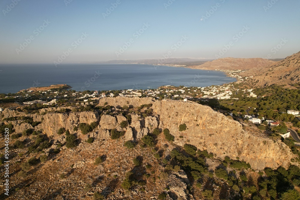 Aerial view of a town on the rocky shore with a blue sky in the background, Rhodes, Greece