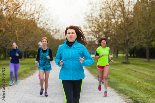 Mature lady leading a group of runners training in nature