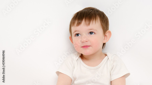 Cute baby on a studio white background. Portrait of a smiling pretty child. Kid aged about two years (one year nine months)