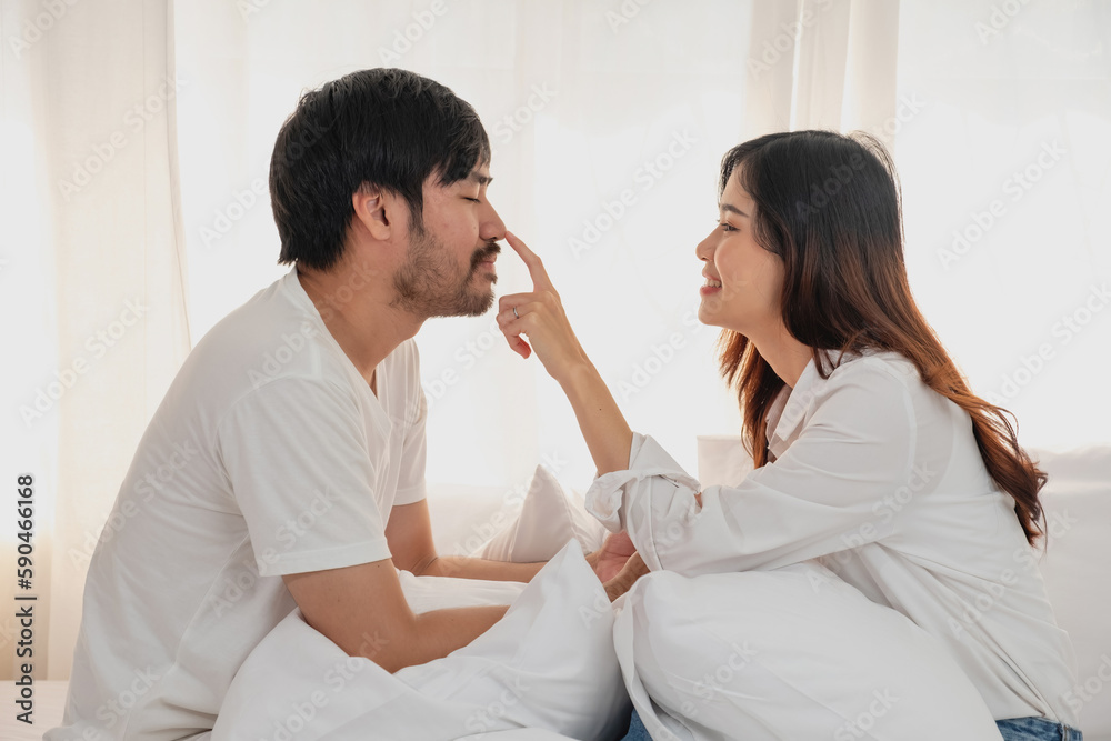 Happy young asian couple embracing, teasing, playing cheerfully in bed at home, romantic time to enhance family bonding. family concept. Happy young asian couple embracing, teasing, playing cheerfully in bed at home, romantic time to enhance family bonding. family concept.