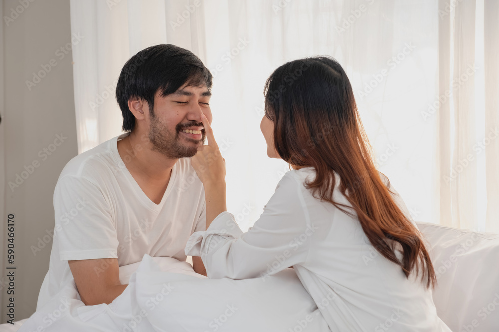Happy young asian couple embracing, teasing, playing cheerfully in bed at home, romantic time to enhance family bonding. family concept. Happy young asian couple embracing, teasing, playing cheerfully in bed at home, romantic time to enhance family bonding. family concept.