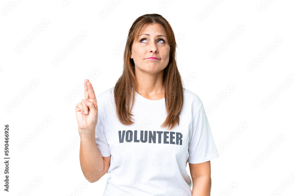 Middle age volunteer woman over isolated background with fingers crossing and wishing the best Middle age volunteer woman over isolated background with fingers crossing and wishing the best