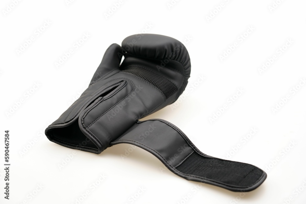 Single black boxing glove with an open strap isolated on a white background Single black boxing glove with an open strap isolated on a white background