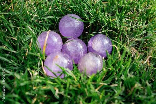 Closeup shot of amethyst stones isolated on the background of the grass