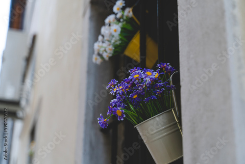 Purple flowers inside a bucket shaped vase