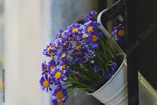 Purple flowers inside a bucket shaped vase