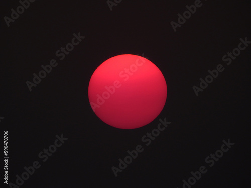 red sun of sunset on black sky background