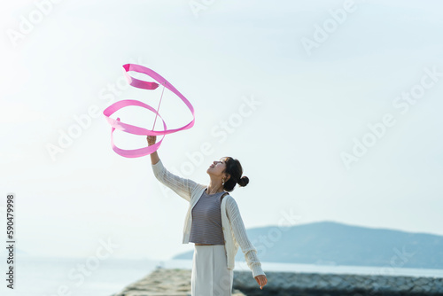 海でリボンを操る女性 photo