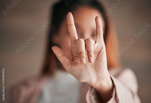 Hand, sign language and love with a person closeup in studio on a blurred background for communication. Emoji, icon or affection and an adult indoor to gesture romance with a fingers icon signal