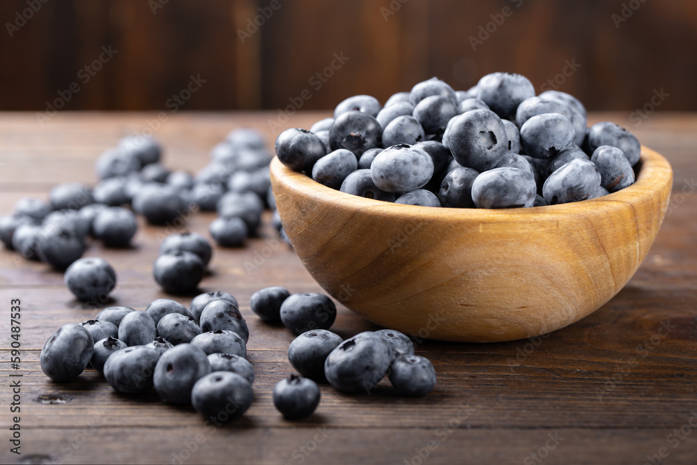 Fresh blueberry in wooden bowl. Concept of healthy and dieting eating.