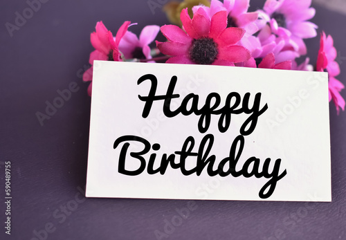 A closeup picture of a Happy Birthday card with Pink flowers.