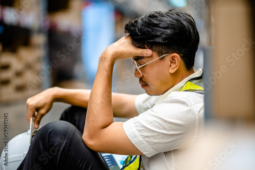 Warehouse workers sitting on the floor feeling exhausted from hard work in a factory, weak, hopeless, burned out, depressed, discouraged, Fired Unemployed Feeling Stressed.