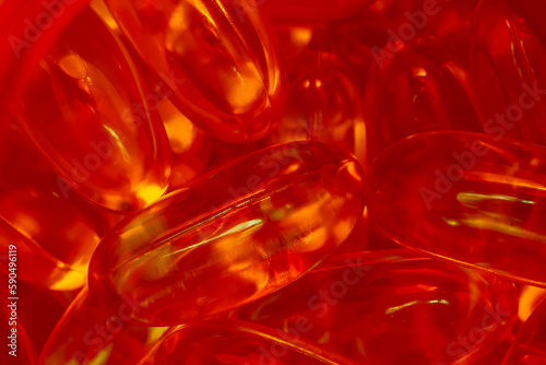lots of yellow gelatin capsules on a red background. omega viramins  close-up  macro