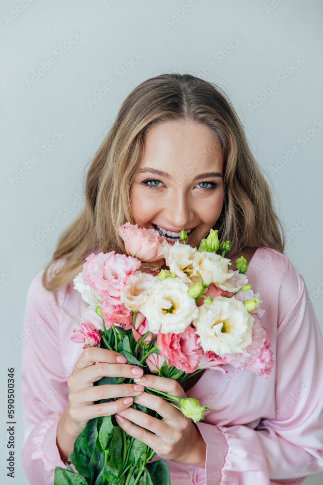 portrait of a blonde woman with eustoma flowers on a white background