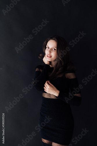 brunette in a black dress on a dark background