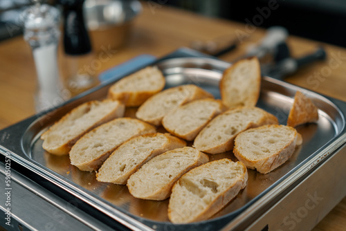 Professional kitchen fresh slices of bread with seasonings lie on a baking sheet close-up of the dish