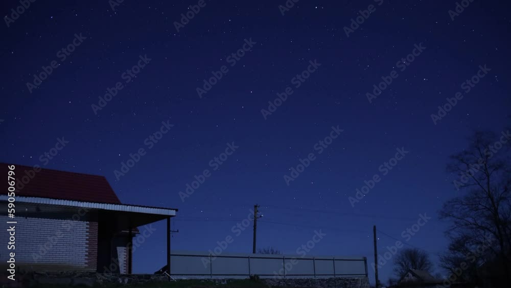 The movement of stars in the night sky against the background of a village house. The movement of stars in the night sky against the background of a village house.