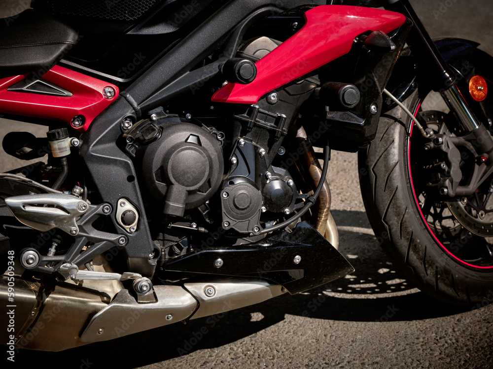 Close-up of a modern motorcycle engine with frame and exhaust system tuning. Close-up of a modern motorcycle engine with frame and exhaust system tuning.