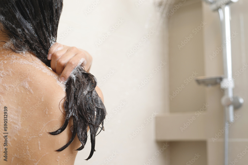 Naklejka premium woman taking shower and washing hair with shampoo