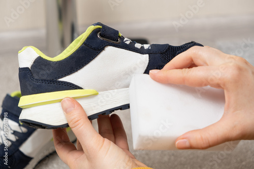 Cleaning of children's shoes, sneakers, soles from dust and dirt with a melamine sponge photo