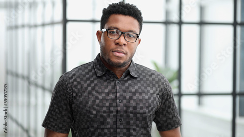 Handsome businessman frowning at camera in his office photo