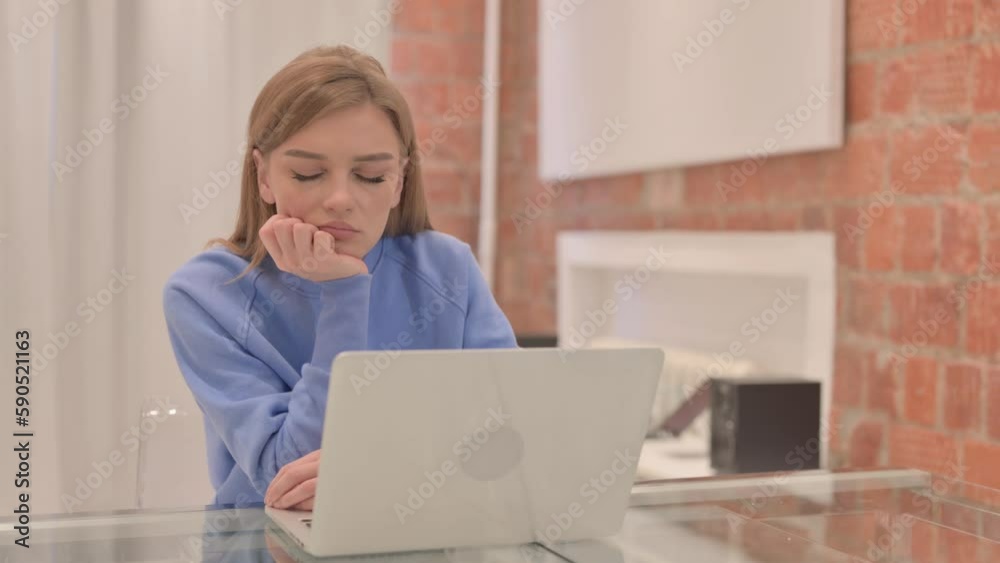 Tired Young Woman Sleeping while Sitting in front of Laptop