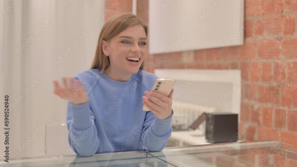 Young Woman Celebrating Success on Smartphone Young Woman Celebrating Success on Smartphone