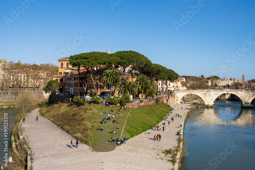 Rom, Italien, Apr. 2023 Menschen genießen die Ruhe auf der Tiberinsel an einem warmen sonnigen Frühlingstag photo