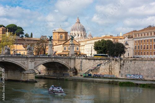 Rom, Italien, Apr. 2023 Blick von der Ponte sant Angelo zum Vatikan mit der Kuppel des Petersdoms im Hintergrund, auf dem Fluß ein Touristenschiff