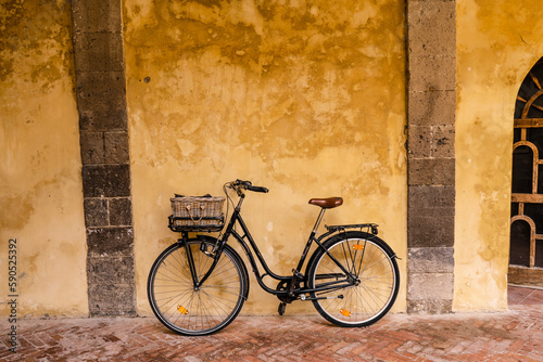 A bicycle leaning against the wall inside Saint Francis cloister in Sorrento, Italy photo