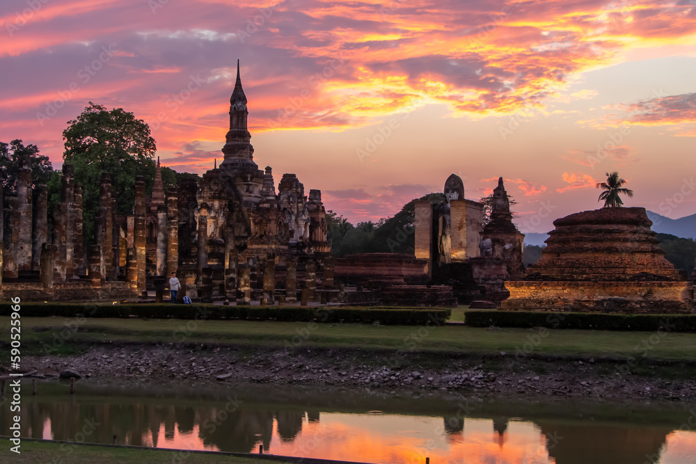 Obraz premium Ancient temples in Sukhothai Historical Park, Thailand, orange sunset
