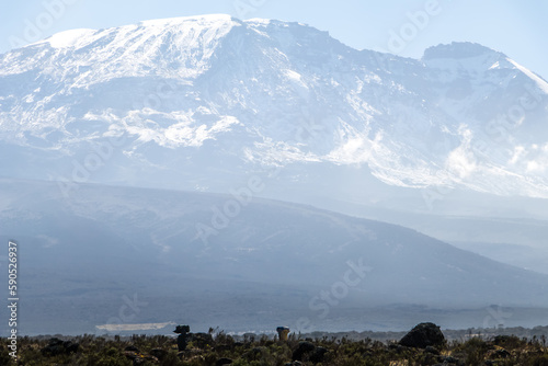 Mount Kilimanjaro with native porters carrying pack on their heads