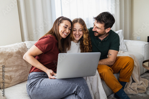 Happy family using laptop together, surfing the internet.