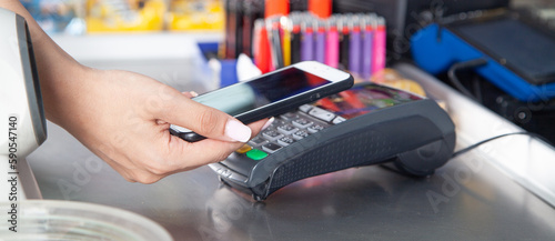 Customer paying for purchases contactless with smartphone.