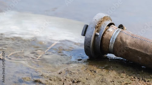 Wastewater sewage pipe dumps the dirty contaminated water into the river. Water pollution, environment contamination concept.