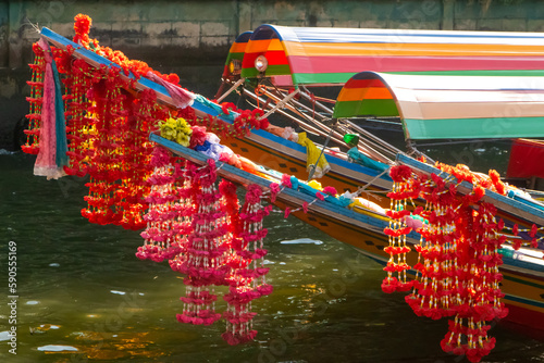 Photography Colourful flowers hanging of the bow of traditional boat in Bangkok