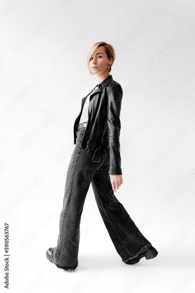 Full body of self assured young female with blond hair model standing against white background Full body of self assured young female with blond hair model standing against white background